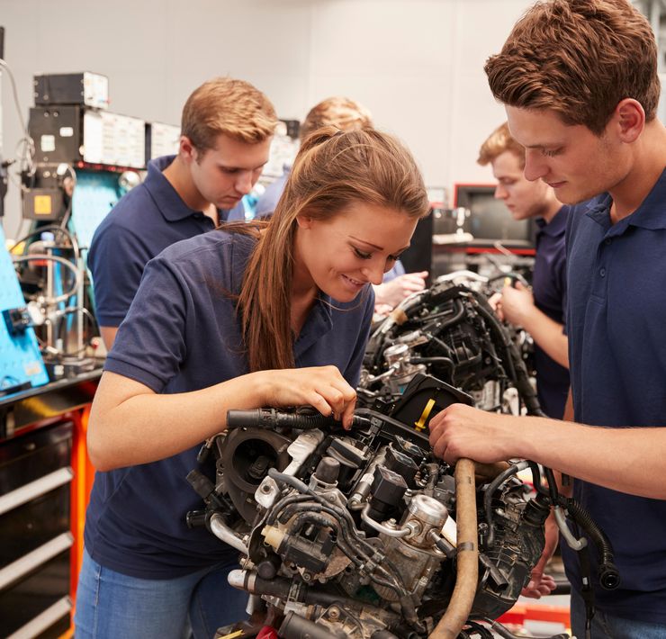 Jugendliche betrachten einen Motor